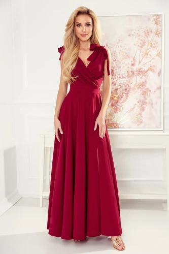 Długa suknia Elena w głębokim odcieniu czerwieni charakteryzuje się eleganckim krojem z wiązaniami na ramionach. Suknia Elena jest idealna na wyjątkowe okazje, podkreślając sylwetkę dzięki dopasowanej górze i rozkloszowanemu dołowi.}