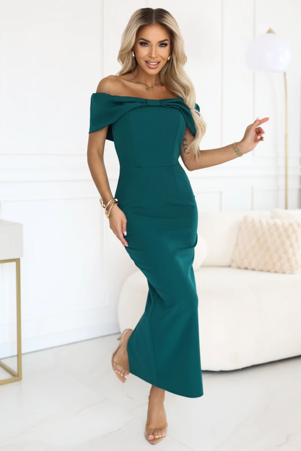 Modelka w eleganckiej butelkowej sukience hiszpance z kokardą na dekolcie i dopasowanym krojem midi